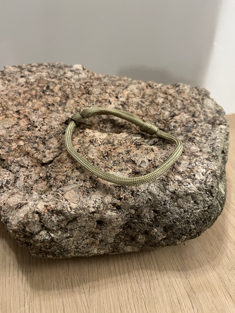 Et armbånd i beige/gull enkel knute